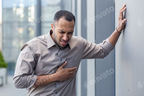Preview: Worried young man clutching chest in pain, suffering from heart attack, health emergency concept