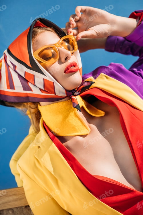 Preview: elegant charming woman posing in yellow sunglasses and colorful clothes