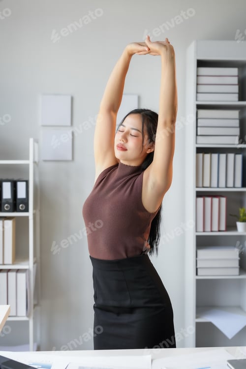 Preview: Businesswoman is relieving stress with a quick stretch break at her desk during a busy workday