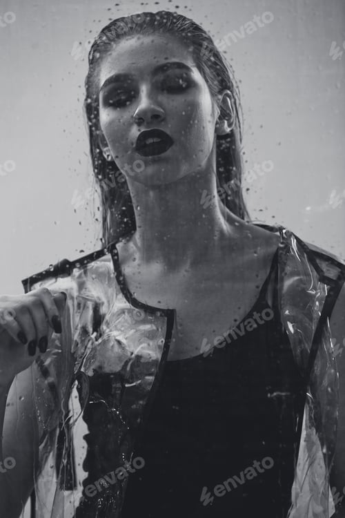 Preview: Young stylish girl with wet hair and dark lipstick dressed in black swimming suit and transparent
