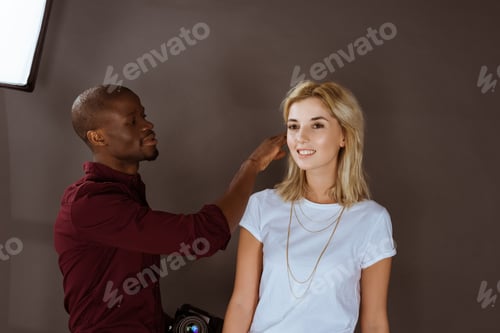 Preview: portrait of multiethnic photographer and model having photoshoot in studio