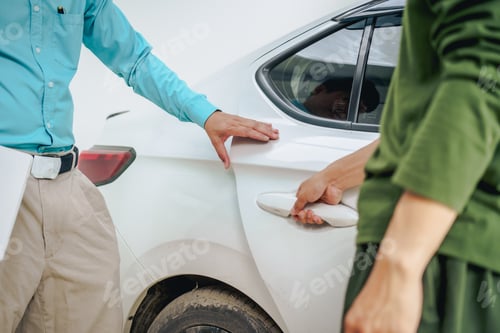 Preview: Asian clients engage with a car insurance agent beside a wrecked vehicle. examine policy details