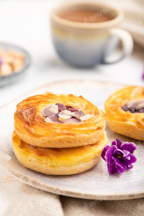 Preview: Small cheesecakes with jam and almonds with cup of coffee on a white concrete background