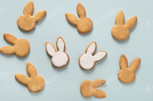 Preview: Easter cookies shaped of bunny on blue. Festive food and kids snacks.