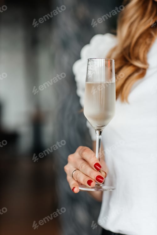 Preview: woman holds a glass of cold prosecco in her hand