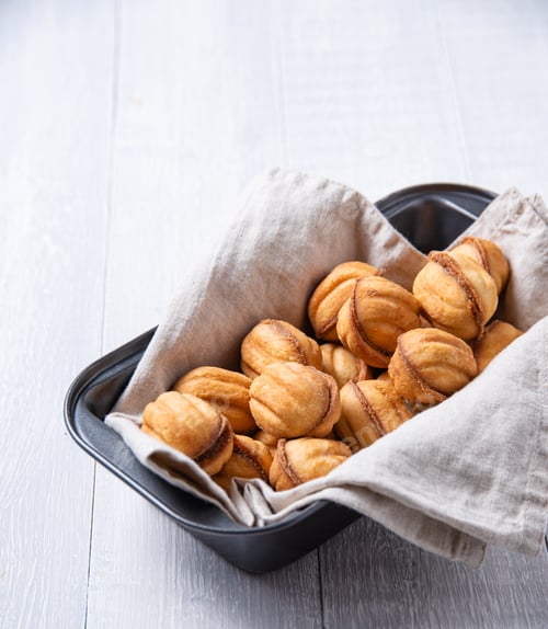 Preview: handmade nuts baked with caramel in a baking dish on a white table