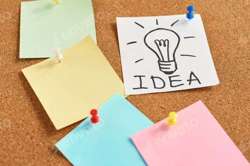 Preview: painted light bulb with word idea and colored blank notes on a cork board
