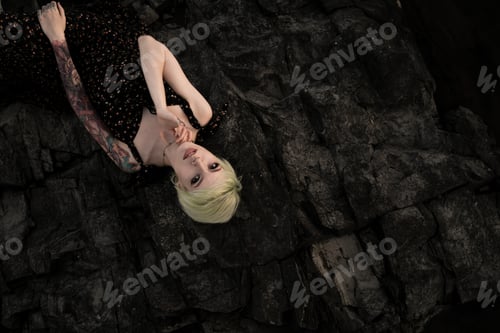 Preview: top view of a girl lying on the stones with a non-standard appearance