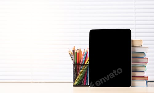 Preview: Tablet with colorful pencils and stack of books