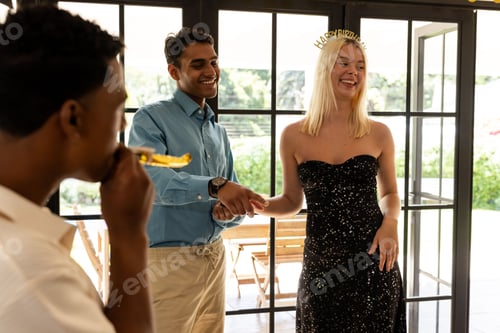 Preview: Celebrating birthday, friends laughing and enjoying party indoors with decorations