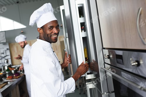 Preview: Multiracial team of cooks working on professional restaurant kitchen