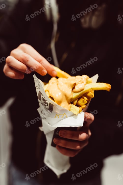 Preview: Close up woman hand holding french fries