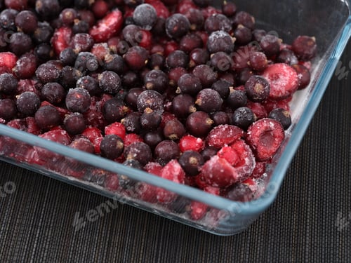 Preview: Frozen black and red currants with cherries in a glass container