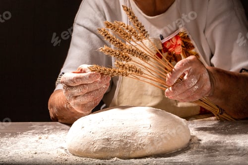 Preview: Bread in the old wrinkled hands of the grandmother close-up. Grandmas bread dough