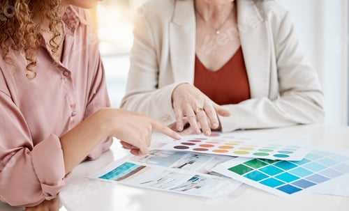 Preview: Closeup of two businesspeople looking at colour swatches while in a meeting together at work. Busin