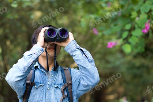 Preview: Young Man watching though binoculars