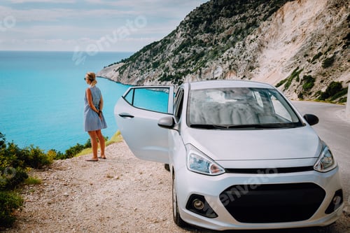 Preview: Women near rented car with open door enjoying Myrtos Beach. Travel vocation concept. Kefalonia
