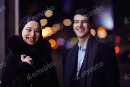 Preview: Happy multicultural business couple walking together outdoors in an urban city street at night near