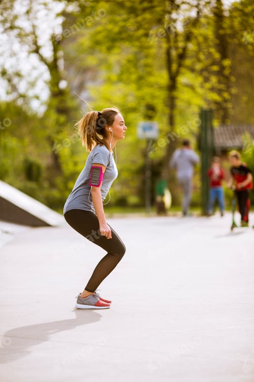 Preview: Young woman having exercise in the park