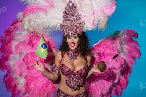 Preview: Cheerful woman in carnival costume with pink feathers holding coconut and Brasil flag isolated on