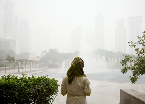 Preview: Young muslim woman waiting for rain to end, Kuala Lumpur, Malaysia