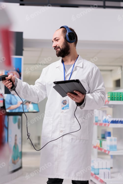 Preview: Pharmacist with headphones listening song while scanning pills packages bar code