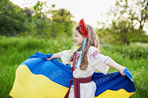 Preview: Ukrainian child girl in embroidered shirt vyshyvanka with yellow and blue flag of Ukraine in field.