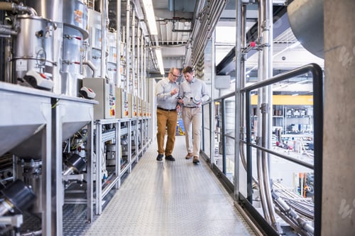 Preview: Two men in factory shop floor talking about product