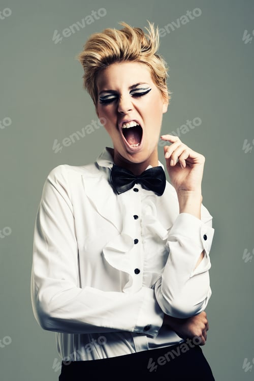 Preview: Twiggy would be proud. Studio shot of an attractive young woman posing against a gray background.