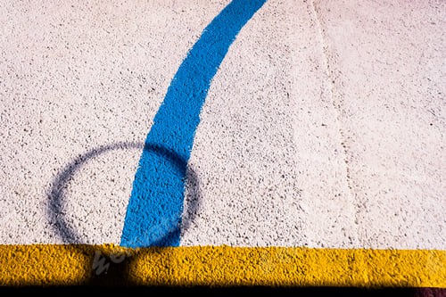 Preview: Shadow of basketball hoop and colored lines on a floor background.