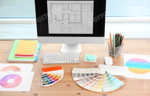 Preview: Designer's workplace with computer and paint color palette samples on table