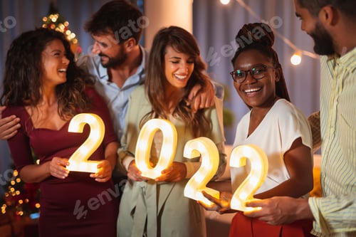 Visualização: Amigos segurando números iluminativos em 2022 enquanto comemoram o Ano Novo