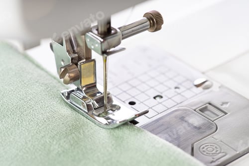 Preview: Modern Sewing Machine Presser Foot With Green Fabric And Thread, Closeup, Macro