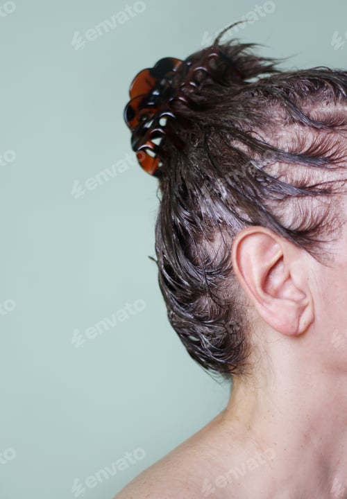 Preview: A woman side view with dyed hair pinched with a barrette