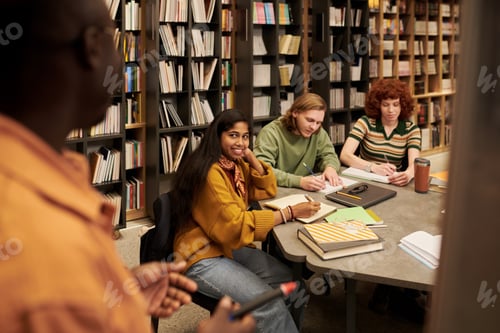 Preview: Multiethnic Group of Young People Studying Together in Library Setting
