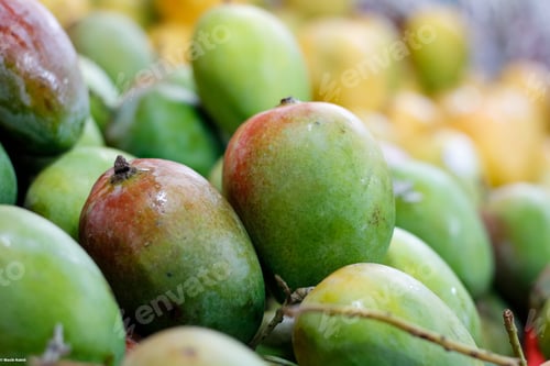Preview: Closeup shot of a pile of ripe mangos at a market