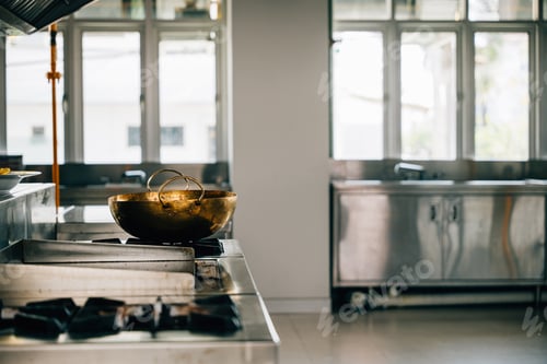 Vista previa: Professional kitchen in a modern restaurant features a shiny metal bowl on the stove. Clean