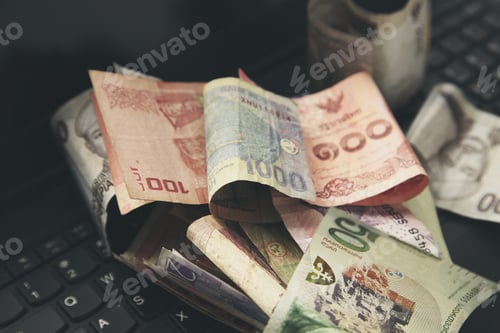 Preview: Money on a laptop keyboard. Foreign exchange rates and trading concept image.