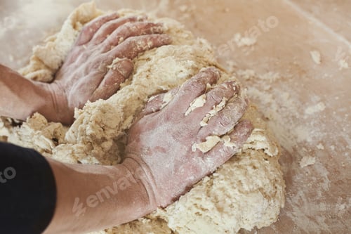 Preview: Male hands kneading dough on wooden table