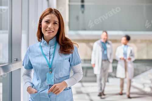 Preview: Portrait of happy nurse working at medical clinic and looking at camera.