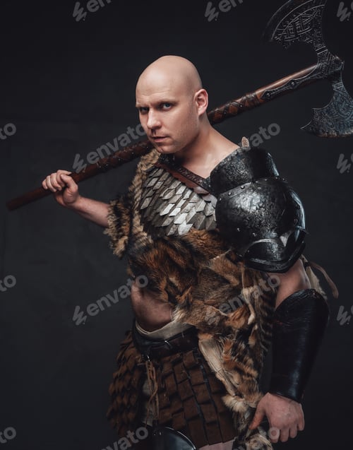 Preview: Hairless ancient warrior holding axes against dark background
