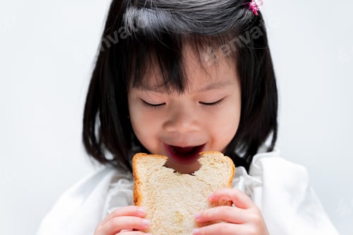 Preview: Portrait little girl eating white bread. On white background.