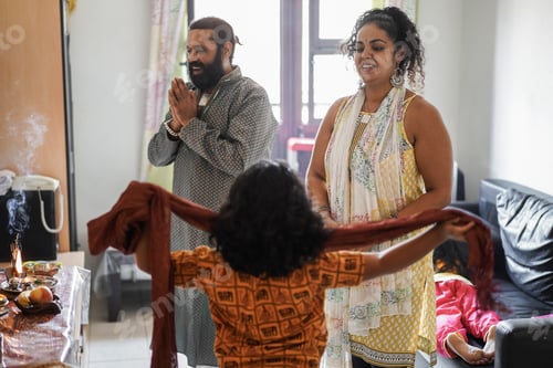 Preview: Indian family celebrating Diwali or hindu festival at home - Soft focus on mother face