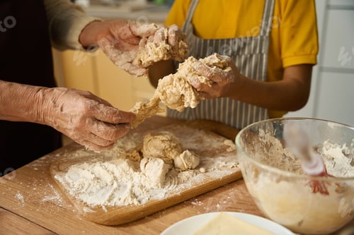 Preview: Grandmother preparing dough for baking with boy