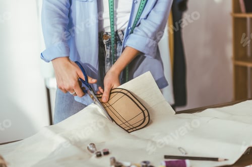 Preview: cropped image of seamstress cutting fabric with scissors