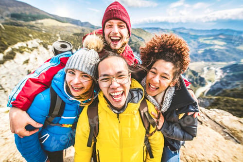 Preview: Multiracial group of young people hiking mountains together