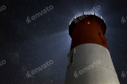 Preview: Low angle shot of an illuminated lighthouse under the sky full of stars