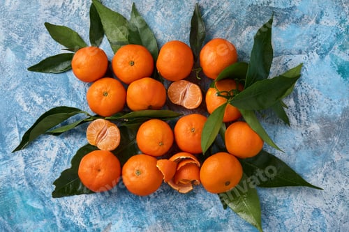 Preview: Tangerines or clementines plucked from leaves on a blue concrete background. Top view