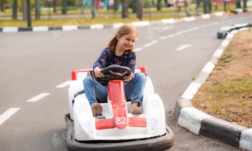 Preview: Happy little girl driving kart in park