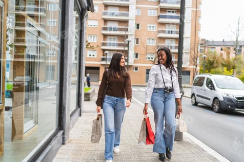 Preview: Diverse women friends walking city street after shopping